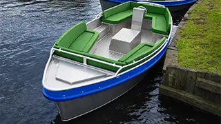 A luxury boat with soft cushions and a steering wheel for 2 to 6 people that you can rent from Giethoorn boat tickets